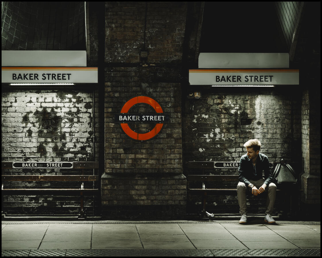 Photo of a man waiting for his tube at Baker Street Station, London